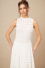Woman wearing a white sleeveless knitted midi dress with cutout details