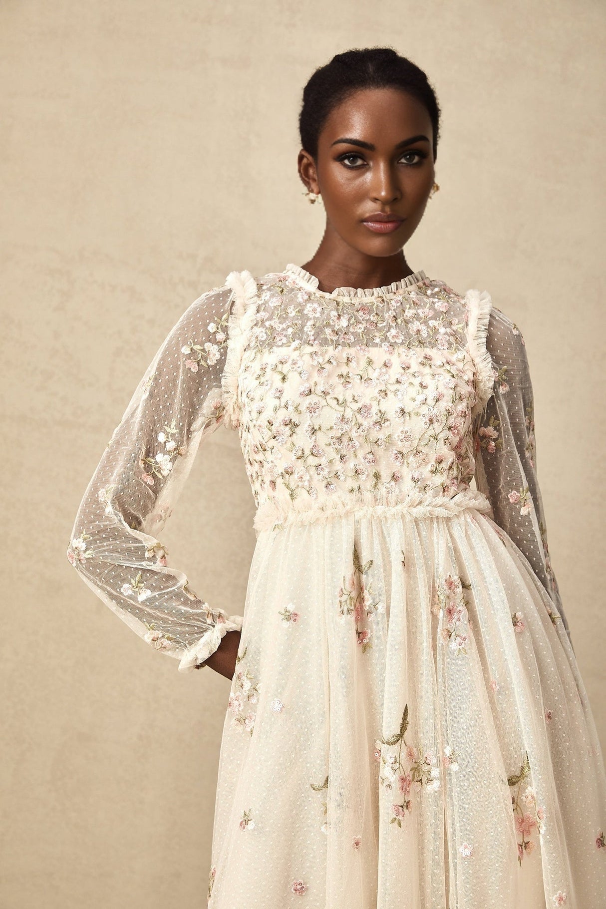 Woman wearing a white tulle midi dress with delicate floral embroidery details by Celine