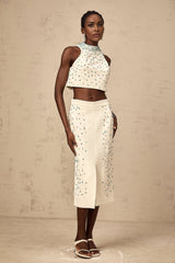 Woman wearing an offwhite matching set with embellished top and skirt named Clothilde