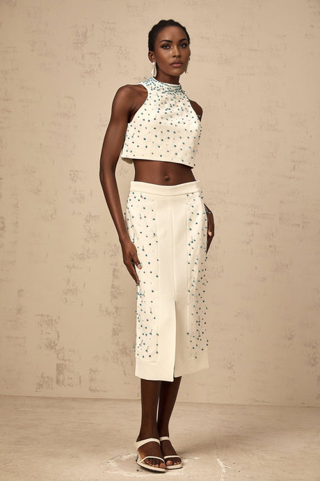 Woman wearing an offwhite matching set with embellished top and skirt named Clothilde