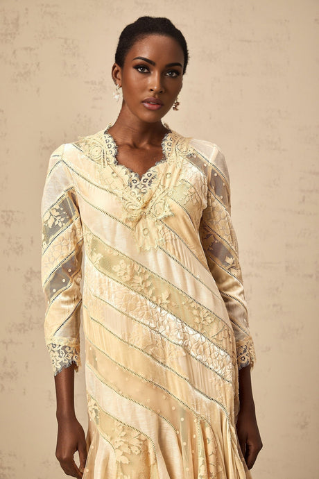 Woman wearing beige midi dress with diagonal stripes and panel detailing