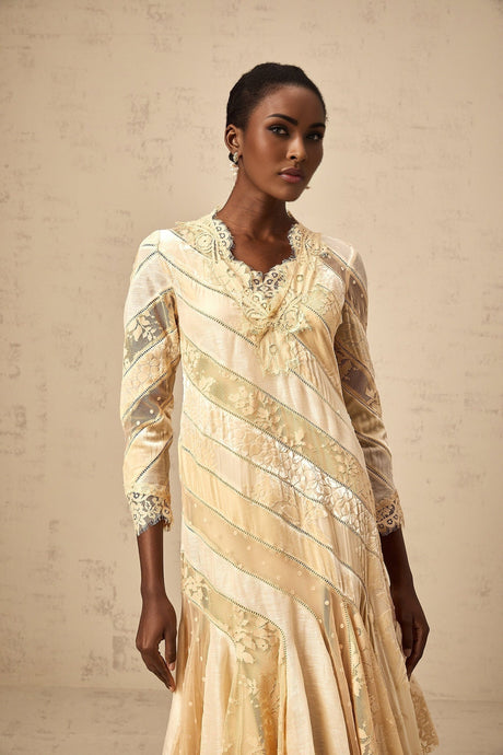 Woman wearing beige midi dress with diagonal stripes and panelled design