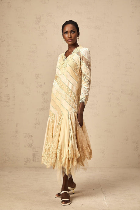 Woman wearing beige midi dress with diagonal stripes and panels