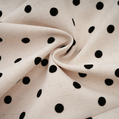 Woman wearing beige polka dot mini dress with puff sleeves and gathered skirt