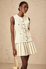 Woman wearing beige sequined knit vest top and matching skirt set