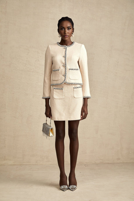 Woman wearing beige tweed cardigan and matching skirt set with crystal accents styled as professional outfit