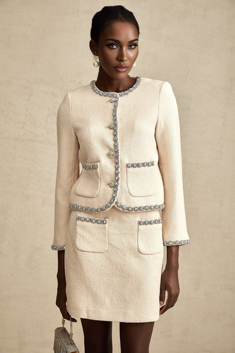 Woman wearing beige tweed cardigan and matching skirt set with crystal embellishments Elisabeth style outfit against plain background