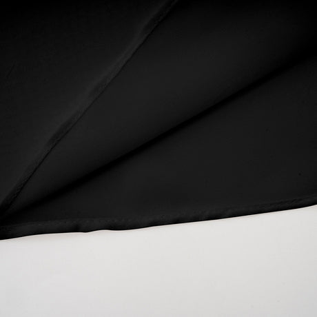 Woman wearing black asymmetric tulle blouse and matching skirt set