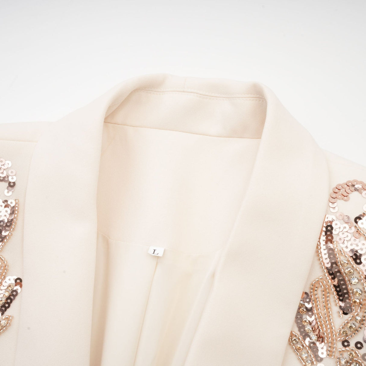 Woman wearing black blazer dress with sparkling sequin embellishments