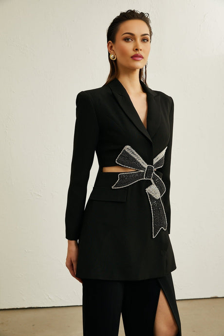 Woman wearing black blazer with bowknot detail and cutout design