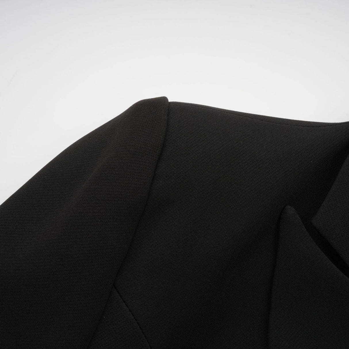 Woman wearing black blazer with bowknot detail and cutout design