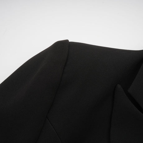 Woman wearing black blazer with bowknot detail and cutout design