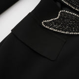 Woman wearing black blazer with bowknot detail and cutout design