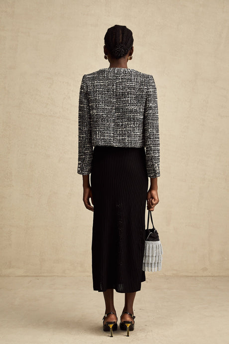 Woman wearing black bouclé tweed jacket with textured fabric and classic design