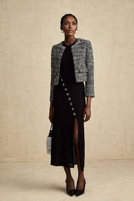 Woman wearing black bouclé tweed jacket with textured fabric and classic tailored design