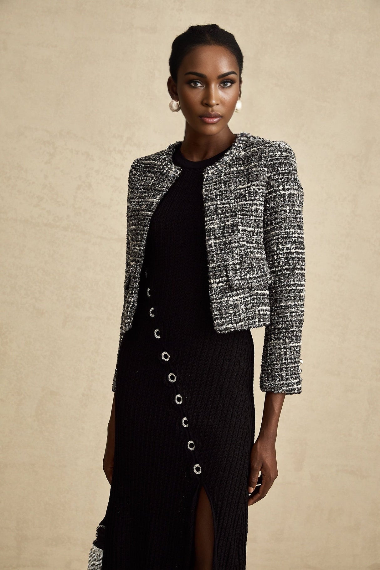 Woman wearing black bouclé tweed jacket with textured fabric and tailored fit