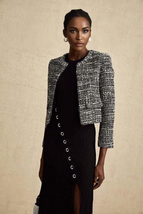 Woman wearing black bouclé tweed jacket with textured fabric and tailored fit