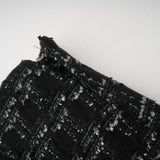 Woman wearing black checked tweed vest top and matching skirt set called Axelle