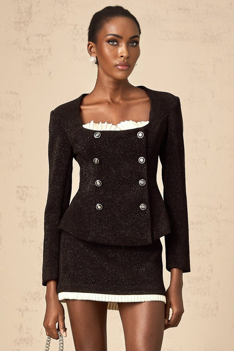 Woman wearing black corduroy matching set with panelled top and skirt