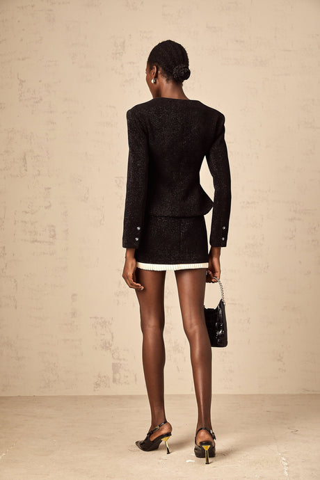 Woman wearing black corduroy matching set with panelled top and skirt