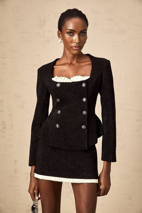 Woman wearing black corduroy matching set with panelled top and skirt