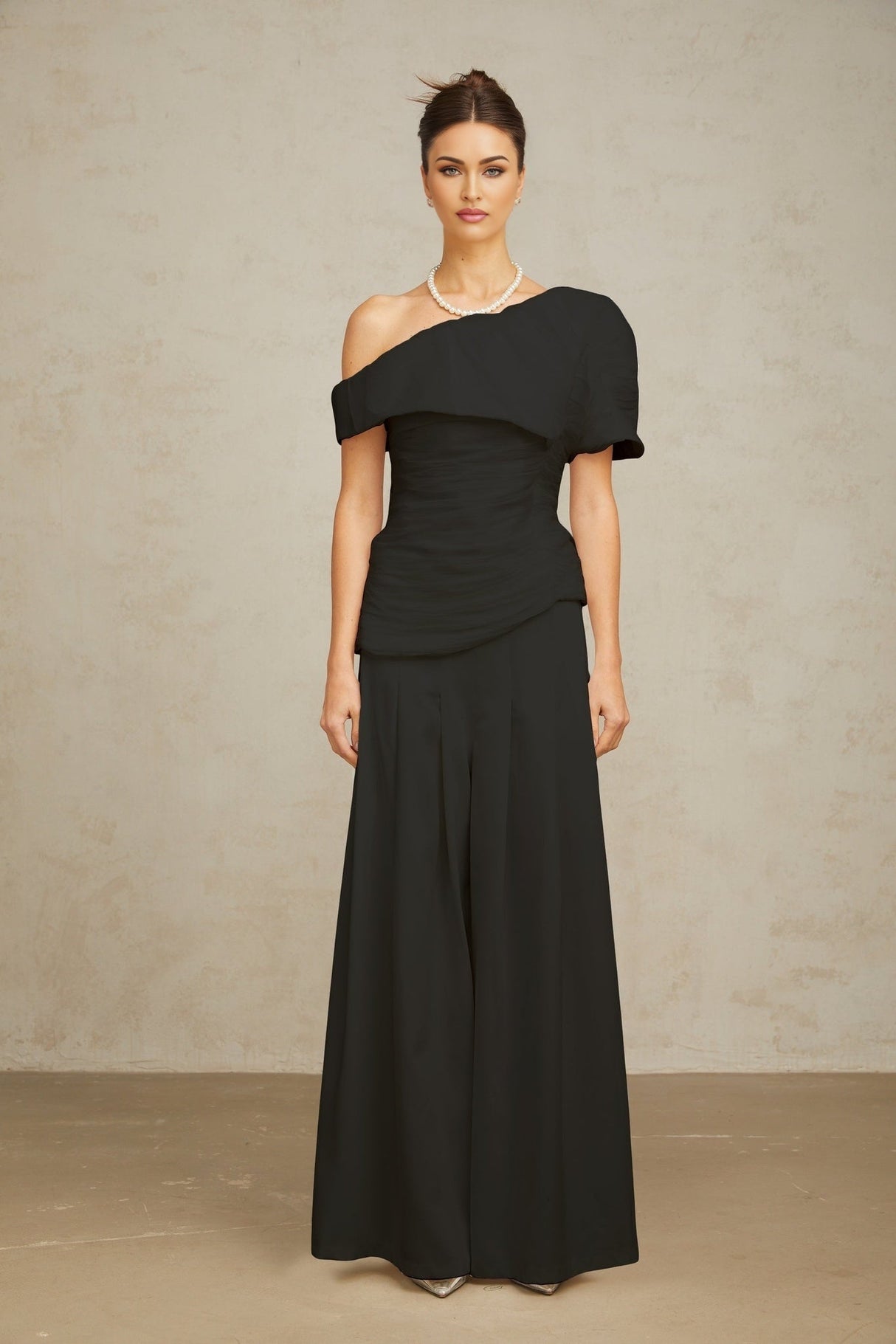 Woman wearing black creased top and matching trousers set