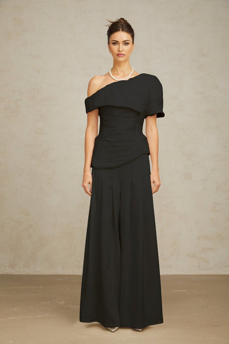 Woman wearing black creased top and matching trousers set