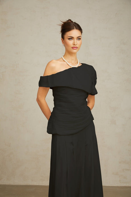 Woman wearing black creased top and matching trousers set