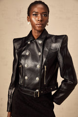 Woman wearing black faux leather jacket with double breasted front closure