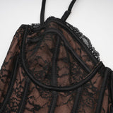 Woman wearing black floral lace sleeveless vest over matching dress with floral lace pattern