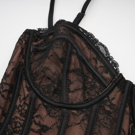 Woman wearing black floral lace sleeveless vest over matching dress with floral lace pattern