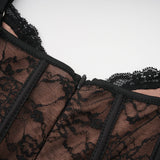 Woman wearing black floral lace sleeveless vest over matching midi dress with lace overlay