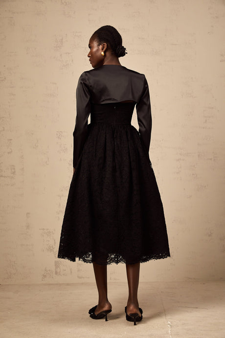 Woman wearing black floral lace top and matching dress set with delicate lace pattern and sheer details