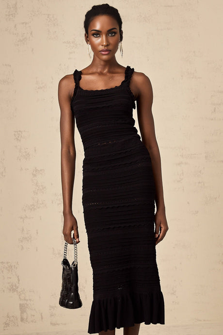 Woman wearing black knitted matching set with ruffled top and skirt