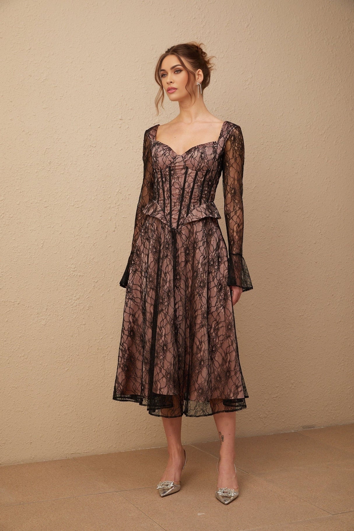Woman wearing black lace midi dress with flared skirt and fitted bodice