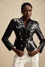 Woman wearing black leather jacket with cinched waist and zipper closure