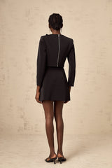 Woman wearing black matching set with crystal embellishments on top and skirt