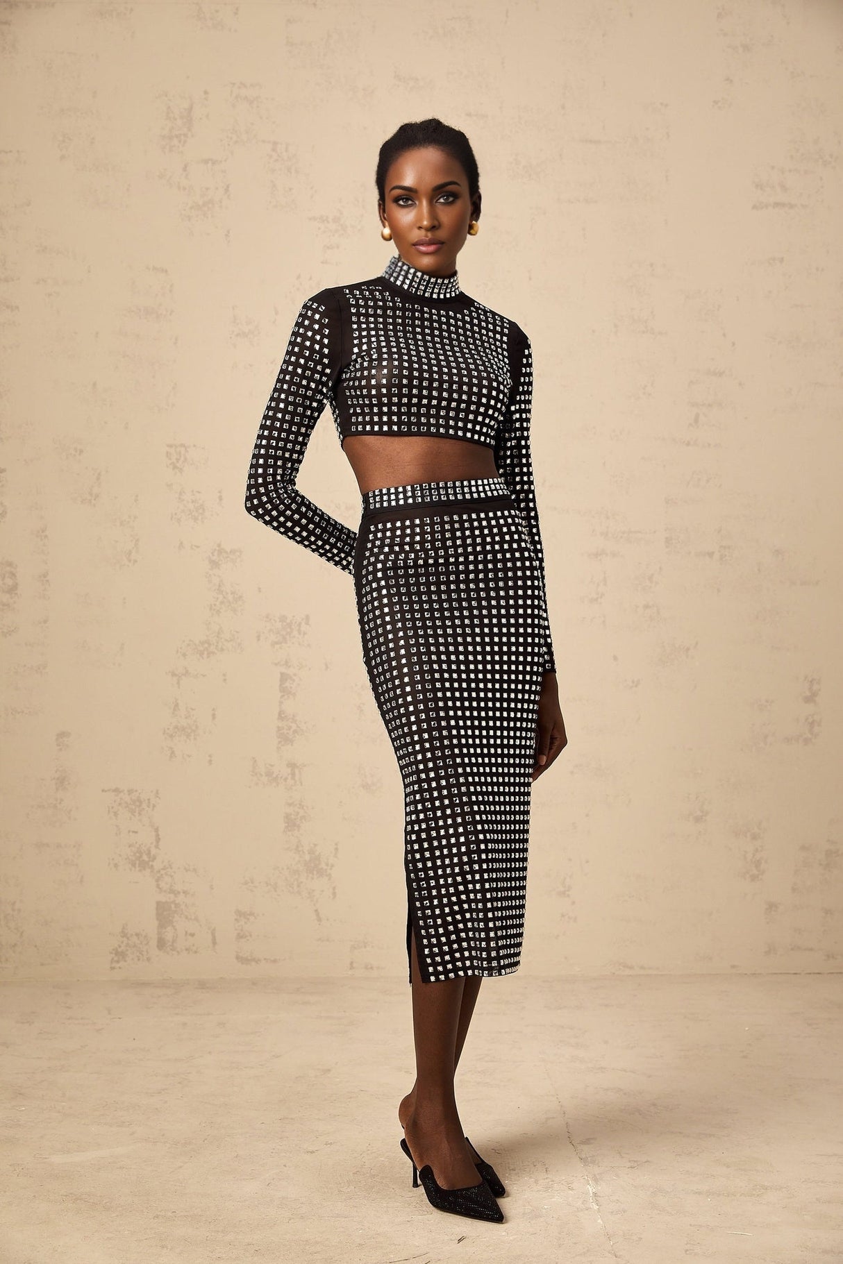 Woman wearing black mesh top and skirt set adorned with rhinestones elegant evening outfit
