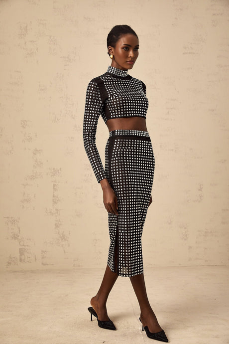 Woman wearing black mesh top and skirt set with rhinestone embellishments elegant sleeveless bodycon design
