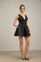 Woman wearing black mini dress with Vneck and flared skirt
