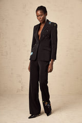 Woman wearing black sequined blazer and matching trousers formal outfit evening wear