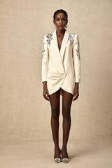Woman wearing black sequined blazer dress with embellishments and long sleeves