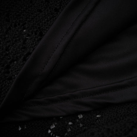 Woman wearing black sequined cardigan and matching skirt set with crochet knit pattern