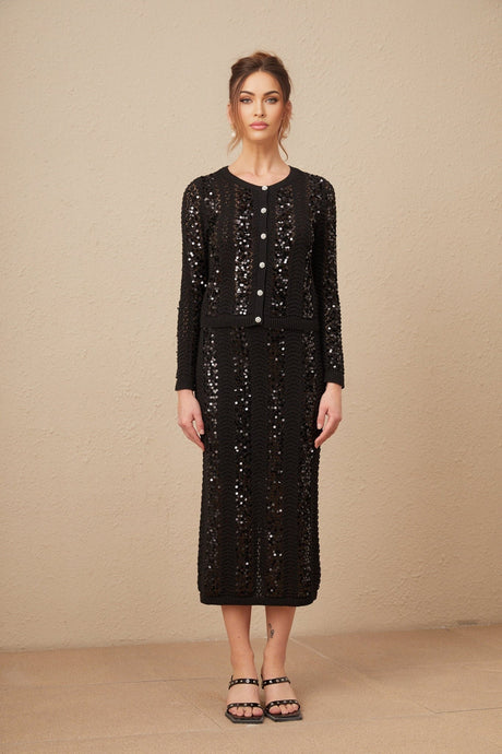 Woman wearing black sequined crochet knit cardigan and matching skirt set