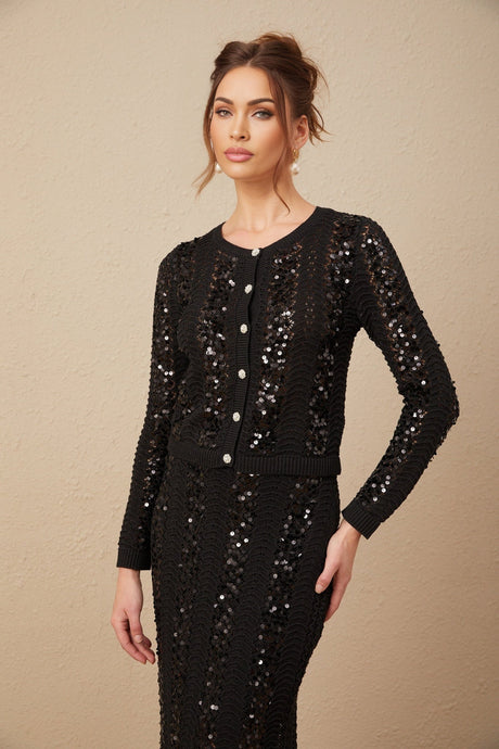 Woman wearing black sequined crochet knit cardigan and matching skirt set