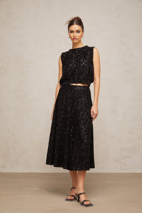 Woman wearing black sequined knit vest and matching skirt set Ulrique brand outfit shimmering formal attire