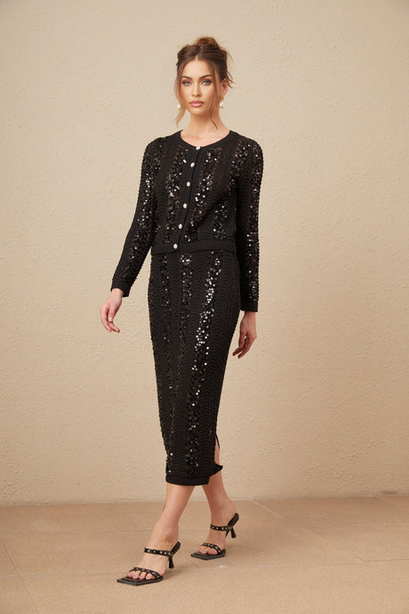 Woman wearing black sequined matching cardigan and skirt set with crochet knit texture