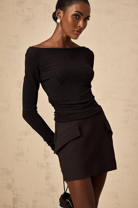 Woman wearing black sequined matching set with sleeveless top and mini skirt