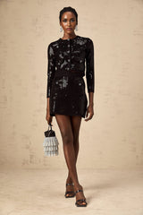 Woman wearing black sequined ribbed knit cardigan and matching skirt set