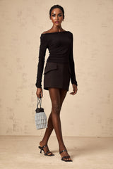 Woman wearing black sequined top and matching skirt set with short sleeves and knee length skirt